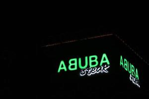 bekasi, indonésie en juillet 2022. logo de steak d'abuba qui brille de mille feux la nuit contre le ciel nocturne sombre. photo