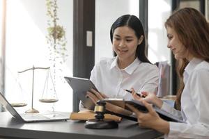 concept de droit des affaires, avocat avocats d'affaires consultent des avocats pour les femmes entrepreneurs pour intenter une action en justice pour droit d'auteur avec ordinateur portable et tablette photo