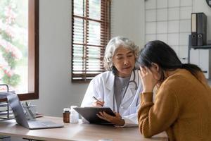 médecin senior aidant une femme dans son bureau. le patient pleure et se sent désespéré