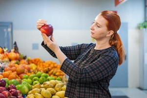 fille caucasienne achetant des produits alimentaires de légumes frais au marché photo