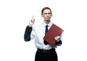 un homme d'affaires en cravate et lunettes avec un magazine dans ses mains sur un fond blanc et isolé photo