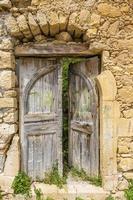 porte ancienne et ruineuse dans un vieux village grec pendant la journée photo