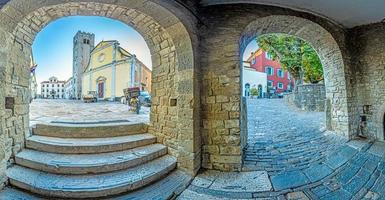 panorama sur la place centrale de motovun avec st. l'église de stephen et la porte de la ville au lever du soleil photo