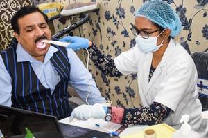 delhi, inde - 19 novembre 2022 - gros plan d'une femme dentiste faisant un examen dentaire de routine au patient, patient allongé sur une chaise lors du bilan de santé annuel, dentiste faisant un examen dentaire au patient photo