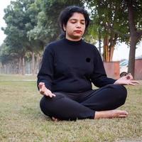 jeune femme indienne pratiquant le yoga en plein air dans un parc. belle fille pratique la pose de yoga de base. calme et détente, bonheur féminin. poses de yoga de base en plein air photo