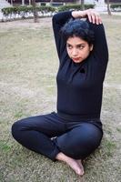 jeune femme indienne pratiquant le yoga en plein air dans un parc. belle fille pratique la pose de yoga de base. calme et détente, bonheur féminin. poses de yoga de base en plein air photo