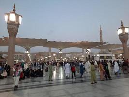 médina, arabie saoudite, décembre 2022 - belle vue du soir à masjid al-nabawi, les visiteurs sont vus dans les lumières de la mosquée dans les locaux de la mosquée. photo