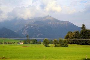 voyage à sankt-wolfgang, autriche. la vue sur le pré vert avec les montagnes en arrière-plan. photo