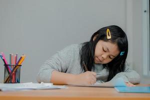 les filles asiatiques s'assoient et travaillent pour les enseignants. photo