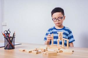 garçon asiatique jouant avec un puzzle en bois photo