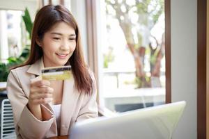 femme d'affaires asiatique séduisante utilisant une carte de crédit pour les paiements de marchandises achats en ligne