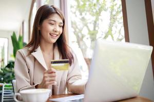 femme intelligente utilise une carte de crédit pour les achats en ligne par ordinateur portable dans le café photo