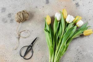 tulipes de printemps, corde de jute, ciseaux sur fond. concept de vacances de printemps. 8 mars et fête des mères. photo