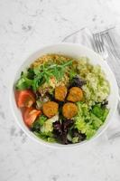 salade mélangée de falafels et de légumes frais sur fond de table en marbre blanc, vue de dessus. concept de nourriture végétarienne et diététique