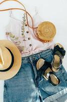 vêtements d'été de mode pour femmes, accessoires. chapeau de paille féminin élégant, short en jean, haut, sandales photo