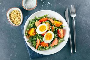 salade de déjeuner en plaque blanche sur fond bleu. vue de dessus, concept d'aliments sains photo