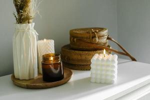 élégante décoration de la maison avec une bougie allumée à mèche en bois dans un bocal en verre brun et des bougies babble. photo