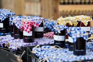 De nombreux bocaux avec de la confiture noire dans un marché photo