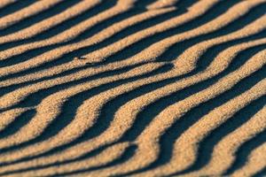 motifs dans le sable de la mer au coucher du soleil photo