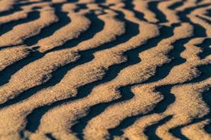 motifs dans le sable de la mer au coucher du soleil photo