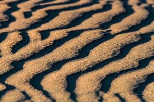 motifs dans le sable de la mer au coucher du soleil photo