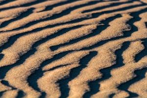 motifs dans le sable de la mer au coucher du soleil photo