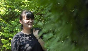 portrait de la femme thaïlandaise asiatique glassese est debout dans le jardin le matin. photo