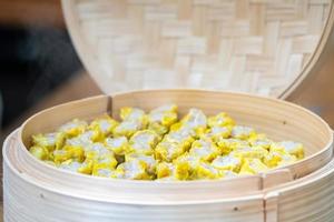 dim sim kanom jeeb la boulette cuite à la vapeur chinoise sur une feuille de bananier dans une assiette en osier de bambou pour l'apéritif du séminaire. photo