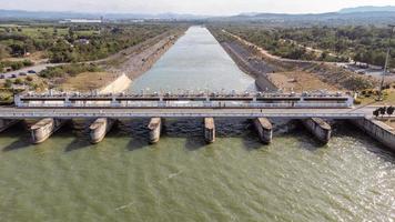 une vue aérienne sur le barrage de pasak jolasid, province de lopburi, thaïlande. suivre le mouvement des vannes qui déversent de l'eau dans les canaux ruraux en énormes quantités d'eau. photo