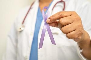 femme médecin asiatique avec ruban violet, signe de la journée de la maladie d'alzheimer, cancer du pancréas, épilepsie, lupus. photo