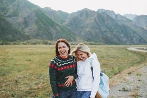 heureux jeunes femmes voyageant sur la route contre le magnifique paysage de montagne photo