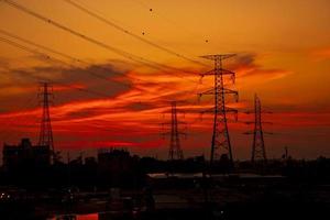 silhouette de pylônes électriques à haute tension avec des paysages colorés après le coucher du soleil photo