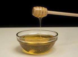 dégoulinant de miel sur fond blanc balancier en bois avec place pour l'espace de copie photo