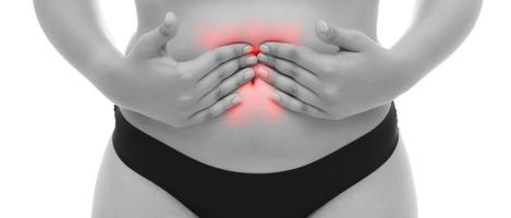 femme souffrant de douleurs à l'estomac tient son ventre douloureux - concept de douleur corporelle photo