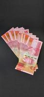 portrait de billets de banque indonésiens rp. 100 000. Monnaie roupie indonésienne isolé sur fond noir photo