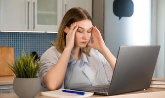 gros plan d'une femme fatiguée assise devant un ordinateur portable.étudiant fatigué ennuyé par l'apprentissage.femme épuisée par le travail.épuisement professionnel, environnement stressant photo