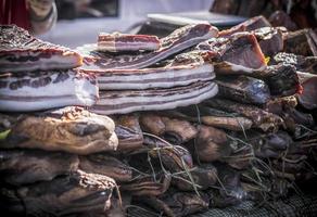 un étal extérieur avec des morceaux de bacon et de la viande séchée vendus photo