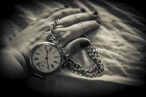 un gros plan de la main d'une femme tenant une montre rétro en noir et blanc photo