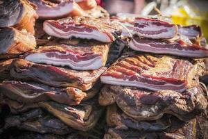 un étal extérieur avec des morceaux de bacon et de la viande séchée vendus photo