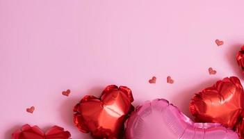 fond de saint valentin avec copie espace et forme de coeur rouge petits et grands ballons en aluminium sur fond rose mise à plat photo