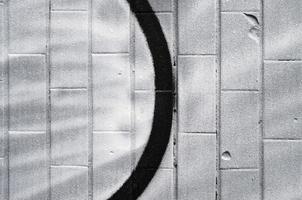 un fragment d'un motif graffiti, appliqué sur un mur de tuiles froides, qui est recouvert d'un fin condensat. le concept d'art de rue par temps inapproprié photo