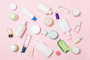 groupe de bouteille de soin du corps en plastique composition à plat avec des produits cosmétiques sur fond rose espace vide pour votre conception. ensemble de contenants cosmétiques blancs, vue de dessus avec espace de copie photo