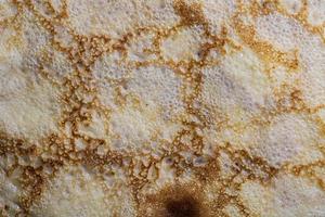 texture et motif de la surface de la crêpe. gros plan de fines crêpes chaudes dans une assiette. cuisine rustique traditionnelle. ressource graphique. photo