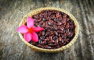 haricots rouges azuki ou graine de grain de haricot rouge sur panier et fleur rose photo