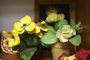 belles fleurs artificielles sur la commode. fleurs jaunes et blanches nature morte. photo