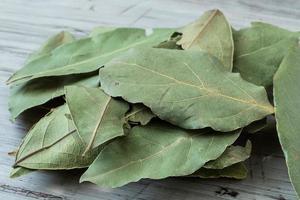 feuilles de laurier entières séchées sur une planche à découper, laurus nobilis photo