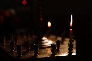 dernière bougie allumée dans une église orthodoxe. bougie d'église brûler sur un grand chandelier d'or dans l'église. photo