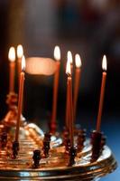 de nombreuses bougies de cire allumées dans l'église orthodoxe. mise au point sélective photo