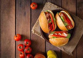 hot-dog - sandwich aux cornichons, paprika et laitue sur fond de bois. vue de dessus photo