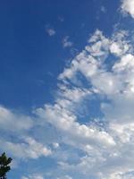 nuages blancs dans le ciel bleu. ciel et infini. beau fond bleu clair. peu nuageux, beau temps. nuages bouclés par une journée ensoleillée. photo